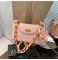 Détail du sac à main rose clair texturé avec chaîne dorée et fermoir rotatif métallique - Rose
