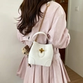 Weiße Eimertasche aus strukturiertem Leder mit goldenem T-Verschluss und Bärenanhänger - Mit Anhänger / Gebrochenes Weiß