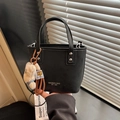 Detail of black matte crossbody bucket bag with plush bear charm and silver rivet studs - Black
