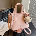 Bolso tipo cubo rosa textura lichi con colgante de oso y correa ajustable - Con Colgante / Rosa