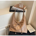 Detailed view of the brown leather tote bag featuring a bow tie and small metal logo - Khaki