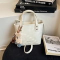 Chic beige leather bucket bag with a cute bear keychain and adjustable strap - White