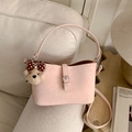 Pink minimalist crossbody bucket bag with decorative bear pendant and leather texture - With Charm / Pink