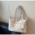 Detalle de bolso tote acolchado gris claro con textura de nailon y bolsillo con presión - Blanco Roto