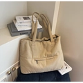 Close-up of khaki canvas tote bag with front zipper pocket on black cushion seat - Khaki