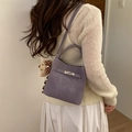 Purple bucket bag with metal twist lock and bear charm worn by a model - With Charm / Purple