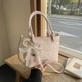 Sac seau rose avec nœud en perles, dentelle et pendentif cœur dans un décor chaleureux - Rose avec pendentif