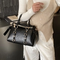 Schwarze Tragetasche aus Knitterleder mit goldener Hardware und seitlichen Schleifen - Schwarz