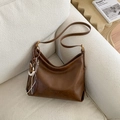 Borsa a tracolla a mezzaluna in pelle marrone caramello con ciondolo intrecciato - Marrone