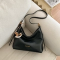 Borsa hobo in pelle nera con tracolla regolabile e ciondolo a cavallo sul divano - Nero