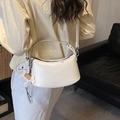 Chic off-white pleated crescent shoulder bag with horse charm on a model side-view - Beige With Charm