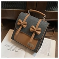Detalle de mochila de mezclilla gris con cuero marrón y lazos sobre un escritorio de estilo retro - Negro