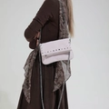 Fashionable light pink studded crossbody bag with silver chain strap worn by a model - Pink