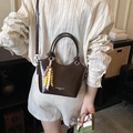 Bolso tipo cubo de charol marrón oscuro con asa superior y colgante de cuentas - Marrón