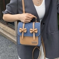 Borsa a tracolla in denim blu con fiocchi marroni e patchwork in pelle su modella - Blu scuro