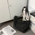 Minimalist black canvas tote bag featuring an adjustable strap and drawstring pocket - Black