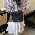 Minimalist black bucket bag featuring golden hardware and two-tone decorative tassel - With Charm / Black