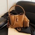 Brown suede bucket bag set featuring decorative tassels and a matching zippered pouch - With Charm / Brown