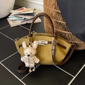 Ginger yellow lychee pattern handbag with contrast brown handles and knit bunny charm - Yellowish Brown With Pendant
