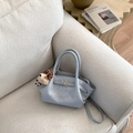 Detail view of light blue bucket bag with leather buckle and plush bear pendant - With Bear Charm / Blue