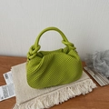 Retro bright green woven handbag with textured pleated design on a cozy white blanket - Green
