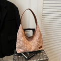 Grand sac cabas en toile fleurie avec bandoulières en cuir marron sur une valise - Marron