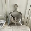Zilveren metallic tote tas met trekkoord en logo label op een witte bank geplaatst - Champagne