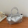 Detail of silver metallic handbag featuring rope knot handle and gathered side texture - Silver