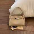 Close-up of beige lychee grain leather handbag with metallic buckle and single handle - Khaki