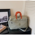 Detail of water-resistant green nylon travel bag with orange handle and NINGJIA logo - Green