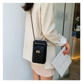Quilted black mini crossbody phone bag with gold hardware and chain strap on a model - Black