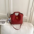 Sac seau rouge vintage en cuir mat avec pendentif ours posé sur un canapé - Avec Pendentif / Rouge