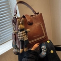 Dark brown retro bucket bag with decorative wide woven strap and rabbit charm - With Ornament / Red Brown