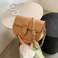 Khakifarbene Satteltasche mit Krokoprägung und goldener Schnalle in der Hand - Milchtee-Farbe