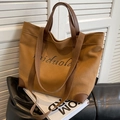 Sac cabas en toile marron avec finitions en cuir et motif vintage sur canapé - Marron