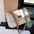 White quilted flap bag with silver chain strap and metal turn-lock closure in natural light - Universal Specification / White