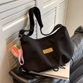 Black nylon dumpling bag with adjustable strap and peach plush charm in variant color - Black with Pendant