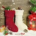 Klassische gestrickte Weihnachtssocken in Rot und Cremeweiß vor rustikalem Holzhintergrund - Rot