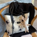 Große cremefarbene Canvas-Einkaufstasche mit Blumenmuster und Hasenanhänger auf Holzstuhl - Beige Schwarz Mit Anhänger