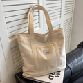 Large cream canvas tote bag with minimalist logo for casual commuting and daily use - Off White