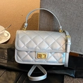 Silver quilted crossbody bag with metallic finish and gold twist lock in lifestyle setting - Silver