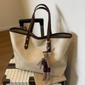 Bolso tote plisado crema con asas marrones y colgante de conejo sobre una maleta - Negro sin Colgante