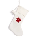 Cream knitted Christmas stocking featuring a red paw print pattern and white pom poms - White Paw Print