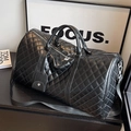Black quilted leather large capacity travel bag with cross-body strap on a dark surface - Large Black