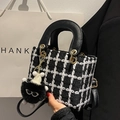 Fashionable black and white plaid tweed handbag with a plush charm and black handles - Black