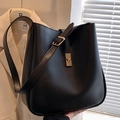 Bolso tipo cubo de cuero negro con acabado mate y elegante cierre de giro dorado - Negro