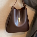 Bolso bombonera minimalista marrón oscuro con cierre de giro dorado y cuero liso suave - Marrón