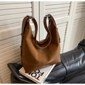 Gros plan détaillé du sac hobo en daim marron sur un livre de mode avec boucle argentée - Brun Jaune
