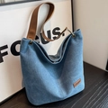 Blue denim tote bag with brown leather handles and fashion label for women - Blue