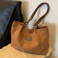 Braune Shopper-Tasche mit Herzprägung und Leder-Patch auf einem Steinsockel - Braun